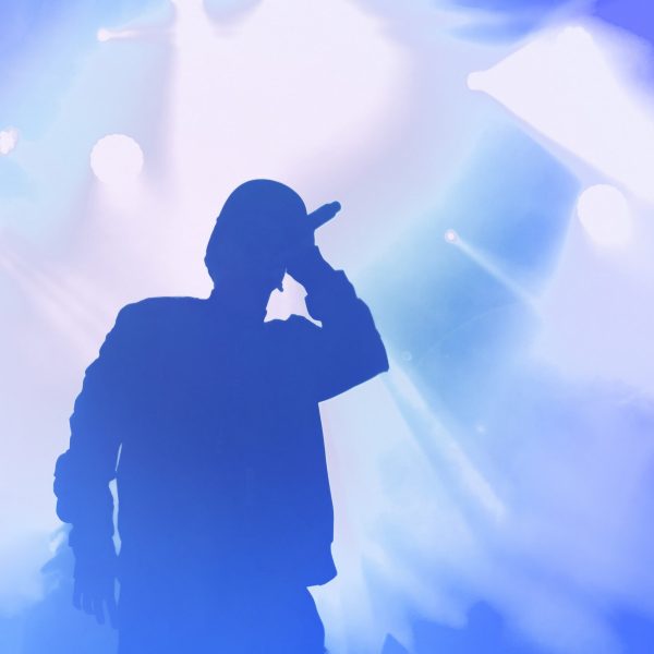 Silhouette,Of,Rap,Singer,Performing,On,Stage.,Bright,Blue,Background